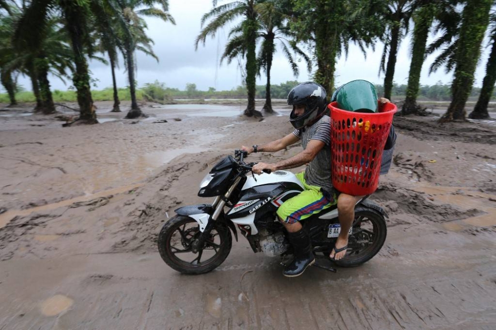 Residents leave their house at the former banana fields of the municipality of El Progreso, Yoro department, Honduras, before the arrival of Tropical Storm Julia on October 8, 2022. Central America is on alert for the approach of Tropical Storm Julia, which is moving through the Caribbean and threatens to become a hurricane before making landfall on the coast of Nicaragua, according to the US National Hurricane Center (CNH) and local authorities. — AFP pic