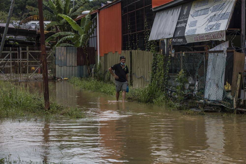 File picture of a man wading through flood waters on Jalan Datuk Panglima Banting in Penampang, Sabah September 15, 2020. — Picture by Firdaus Latif