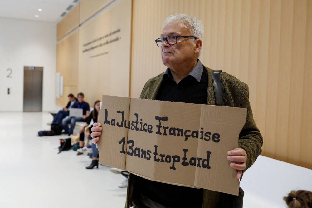 Wilfried Schmid, a family member of a victim, holds a placard that reads ‘French Justice 13 years too late’, on the day of the trial of Air France and Airbus on charges of involuntary manslaughter over the 2009 crash of flight AF447 from Rio de Janeiro to Paris, in Paris, France October 10, 2022. — Reuters pic