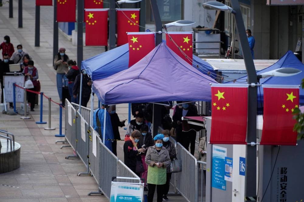 People line up to get tested for Covid-19 at a nucleic acid testing site in Shanghai, China October 10, 2022. ― Reuters pic