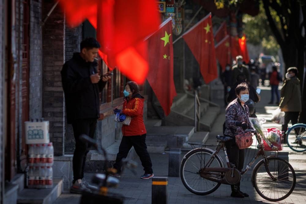 A view of Chinese national flags in a street of an old neighbourhood as the city prepares for the 20th National Congress of the Communist Party of China, in Beijing, China October 11, 2022. ― Reuters pic