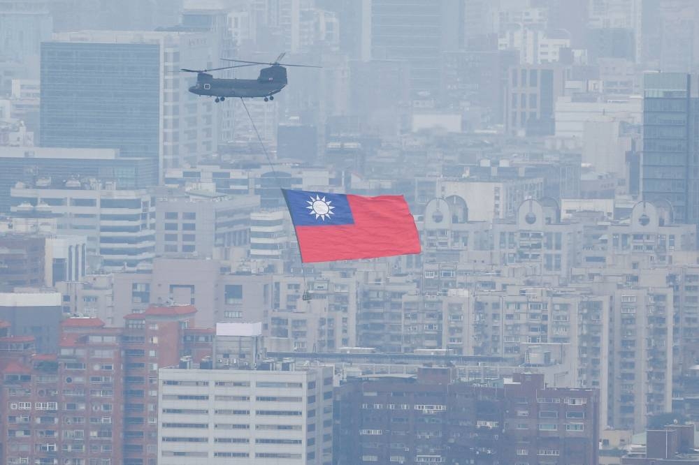 A Chinook helicopter carrying a Taiwan flag flies over the city during the country's National Day celebration in Taipei, Taiwan October 10, 2022. ― Reuters pic