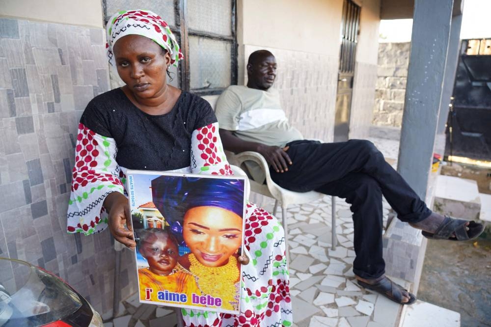 Mariama Kuyateh, 30, holds up a picture of her late son Musawho died from acute kidney failure, in Banjul on October 10, 2022, - Gambian police on October 8, 2022,  announced an investigation into four cough syrups made by the Indian Pharma company Maiden Pharmaceuticals, after the WHO said they could be responsible for the deaths of 66 Gambian children, most under 5-years-old. Nearly half of The Gambia's population lives below the poverty line, according to the World Bank. — AFP pic