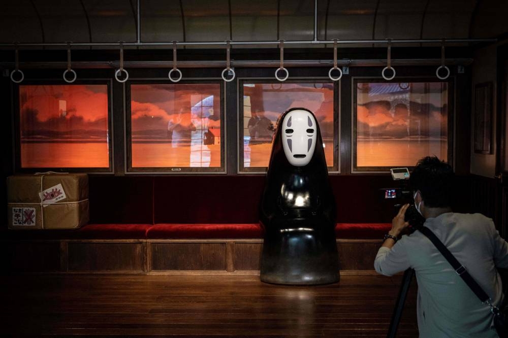 A member of the media takes video of an exhibit at Ghibli's Grand Warehouse during a media tour of the new Ghibli Park in Nagakute, Aichi prefecture October 12, 2022. — AFP pic