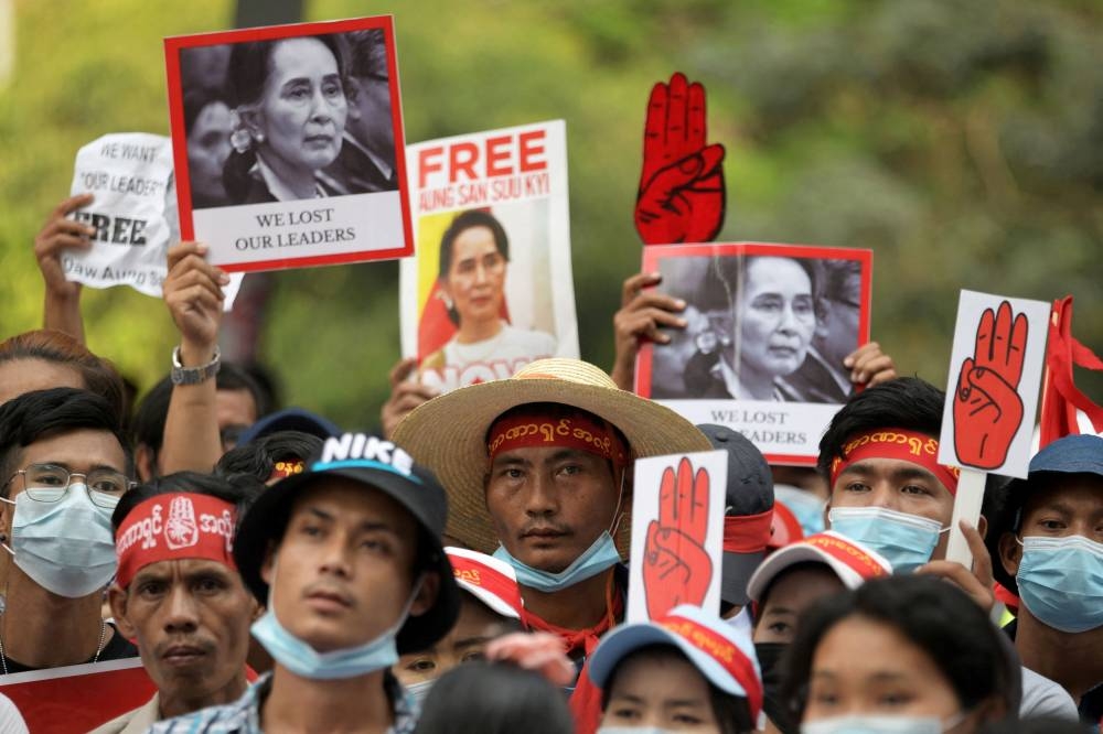 Demonstrators hold placards with pictures of Aung San Suu Kyi as they protest against the military coup in Yangon, Myanmar February 22, 2021. ― Reuters file pic