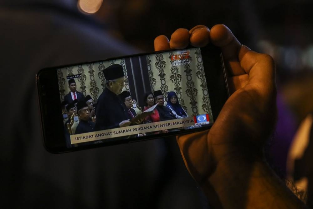 Pakatan Harapan supporters listen watch a live broadcast of the swearing-in of Tun Dr Mahathir Mohamad as the seventh prime minister of Malaysia outside the Istana Negara in Kuala Lumpur, May 10, 2018. — Picture by Yusof Mat Isa
