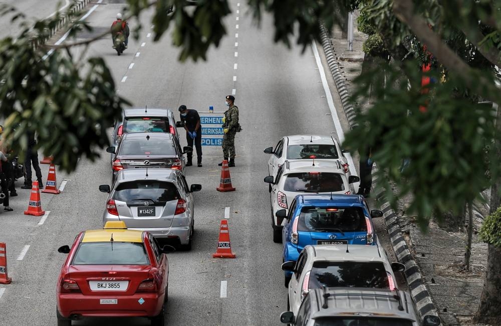 Police personnel conduct a roadblock in Kuala Lumpur during MCO 2.0, February 19, 2021. — Picture by Ahmad Zamzahuri