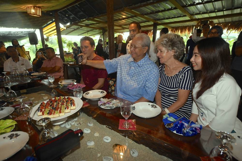 Communications and Multimedia Minister Tan Sri Annuar Musa poses for a picture with two digital nomads staying at the Langkawi Country Lodge at the launch of the second location of the DE Rantau Programme in Langkawi October 16, 2022. — Bernama pic