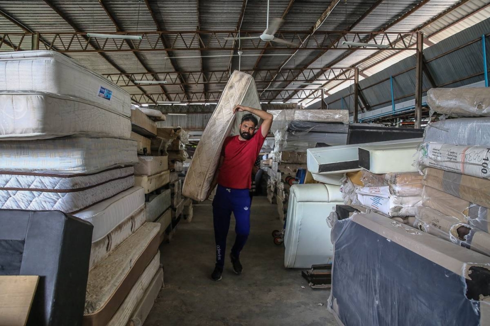 An employee carries a mattress at the Unearth store at Kampung Baru Subang in Shah Alam October 5, 2022. — Picture by Yusof Mat Isa