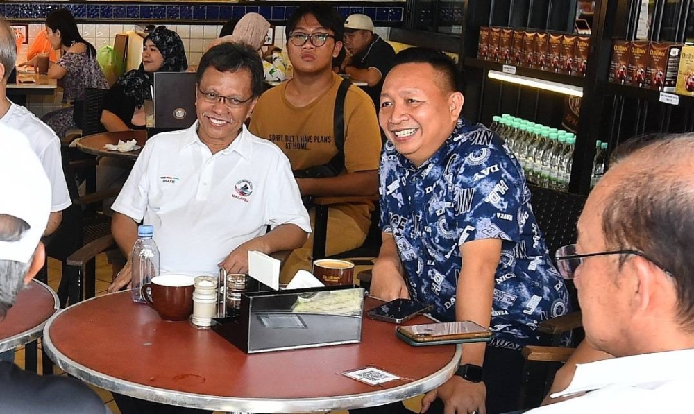 Wetrom (right) sharing a drink with Shafie Apdal at a cafe. — Picture courtesy of Warisan