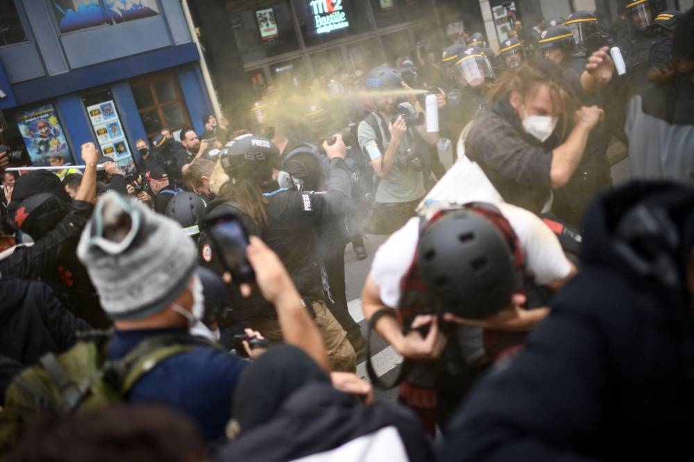 French Compagnie republicaines de securite police use spray against protesters during a rally against soaring living costs and climate inaction called by French left-wing coalition NUPES (New People's Ecologic and Social Union) in Paris October 16, 2022. — AFP pic 
