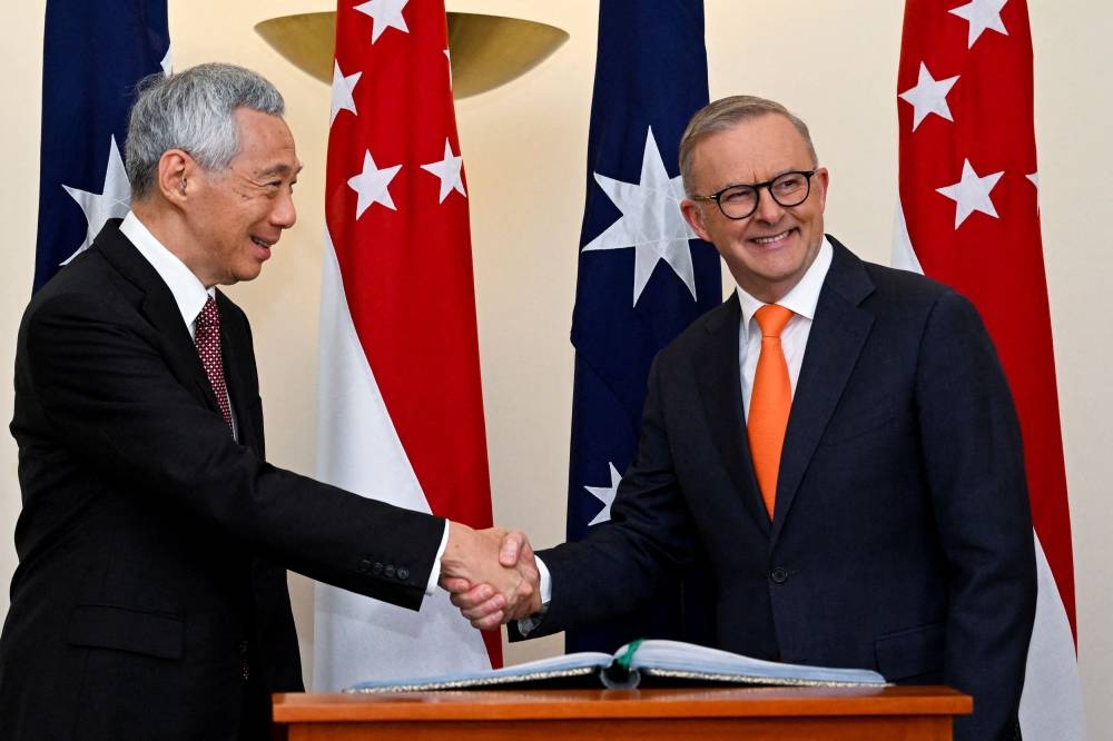 Prime Minister of Singapore Lee Hsien Loong (left) shakes hands with Australian Prime Minister Anthony Albanese during a meeting at Parliament House in Canberra, Tuesday, October 18, 2022. — Reuters pic