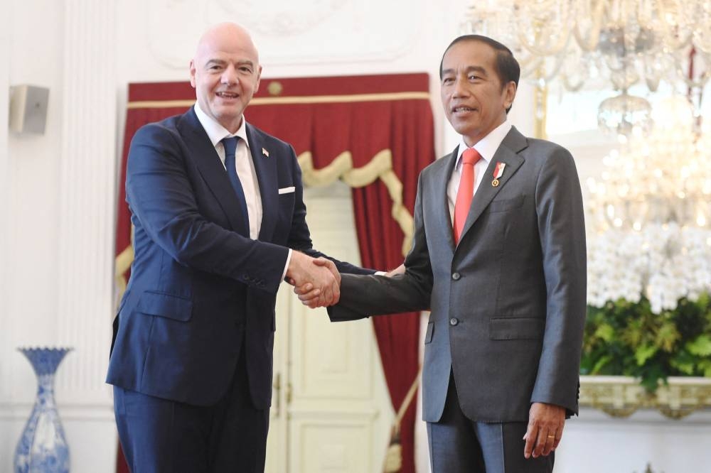 Indonesian President Joko Widodo shakes hands with Fifa's president Gianni Infantino during their meeting at the Merdeka Palace in Jakarta October 18, 2022. — Reuters pic