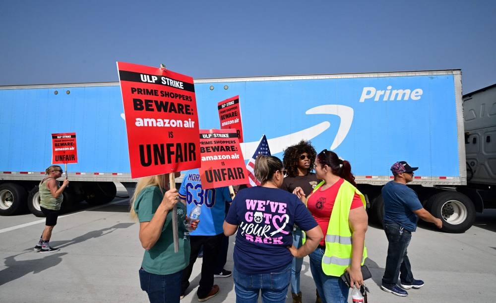 Workers at Amazon's West Coast Air Freight Fulfillment Centre in San Bernardino, California, protest outside the facility on October 14, 2022 over claims of an unsafe work environment and low wages. — AFP pic