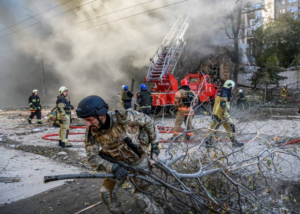 Firefighters help a local woman evacuate from a residential building destroyed by a Russian drone strike, which local authorities consider to be Iranian-made unmanned aerial vehicles (UAVs) Shahed-136, amid Russia's attack on Ukraine, in Kyiv Ukraine October 17, 2022. ― Reuters pic