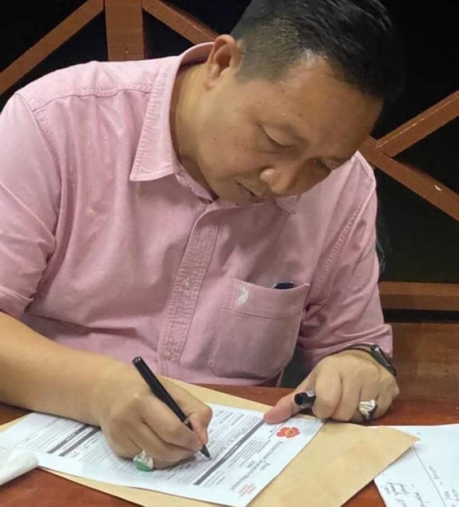 Datuk Wetrom Bahanda filling the KDM membership application form. — Borneo Post pic 