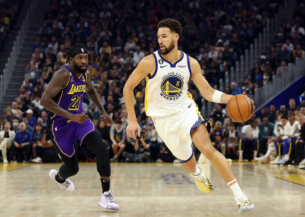 Klay Thompson (left) of the Golden State Warriors controls the ball as Patrick Beverley of the Los Angeles Lakers defends at the Chase Centre in San Francisco October 18, 2022. — AFP pic