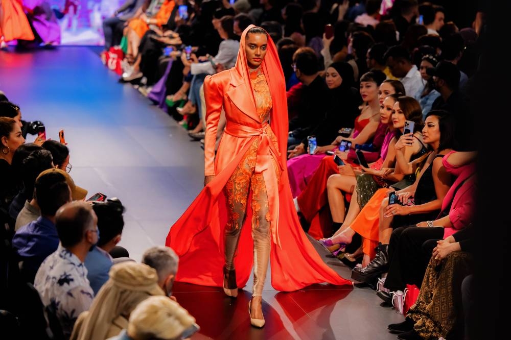Top model Vanizha Vasanthanathan strutting the runway in Syomir's popping burnt orange ensemble with a headscarf. — Picture courtesy of All is Amazing Photography