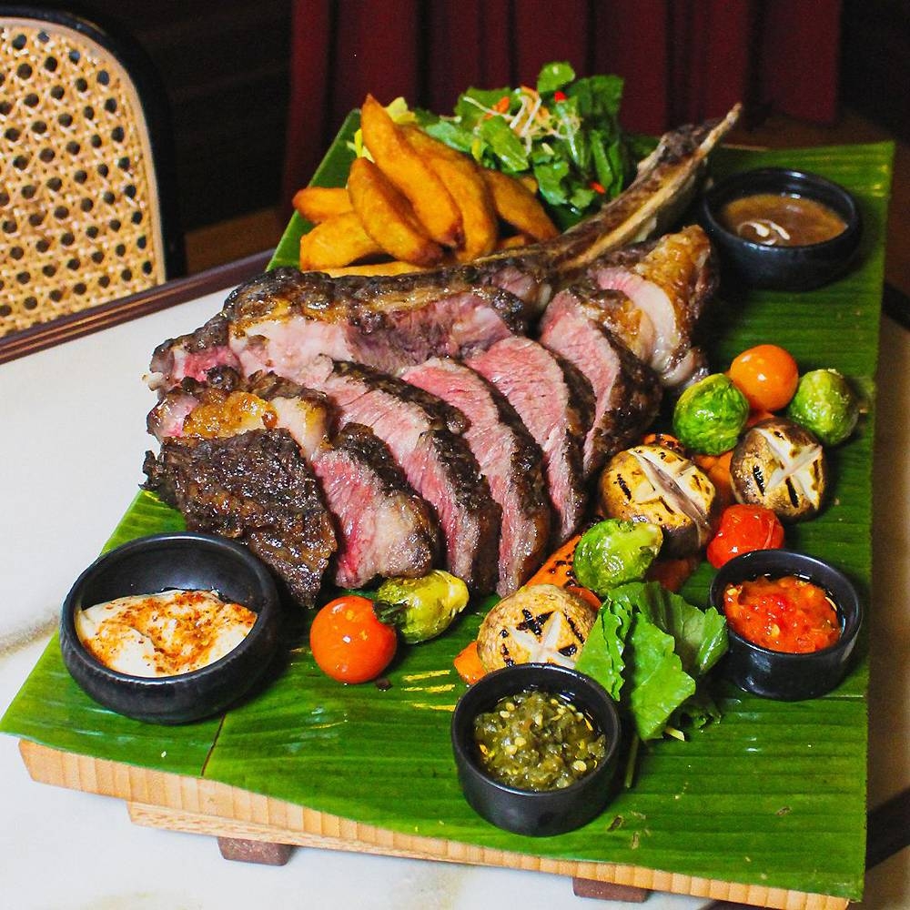 Indulge in their grilled Australian Angus Tomahawk served with classic beef jus, charred seasonal vegetables, 'kerabu mangga' and their signature house-made 'sambal merah'. — Picture courtesy of The Chow Kit — An Ormond Hotel