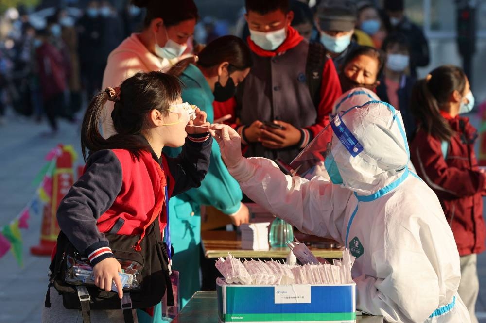 This photo taken on October 19, 2022 shows a woman undergoing a nucleic acid test for the Covid-19 coronavirus in Lianyungang in China's eastern Jiangsu province. — AFP pic
