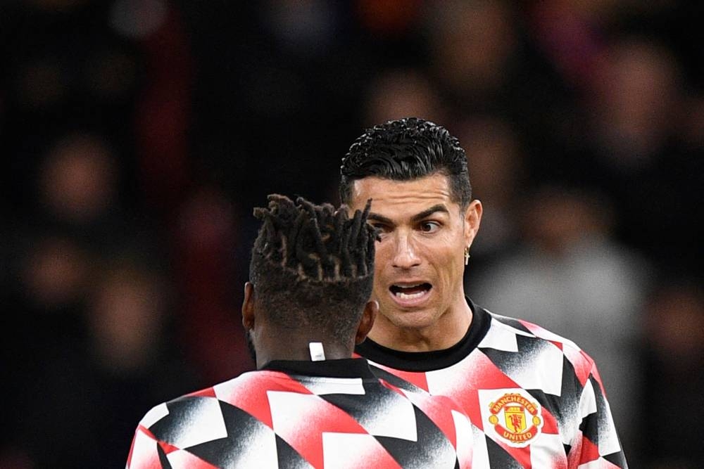 Manchester United striker Cristiano Ronaldo speaks to midfielder Fred during the warm up prior to the match between Manchester United and Tottenham Hotspur at Old Trafford in Manchester, October 19, 2022. — AFP pic 