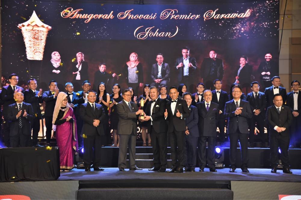 Abang Johari (third left) presents a trophy to Sassoku Tech from the Land and Survey Department. ― Picture courtesy of Information Department