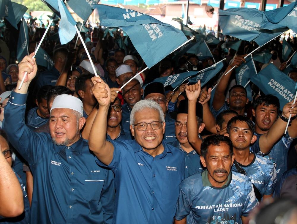 Minister of Home Affairs who is also the incumbent of the Larut Parliamentary seat Datuk Seri Hamzah Zainudin (centre) waving the PN flag when he attended the launch of the PN Larut Parliamentary GE15 campaign at the Taman Sri Permai Open House, Selama in Larut, October 22, 2022. — Bernama pic