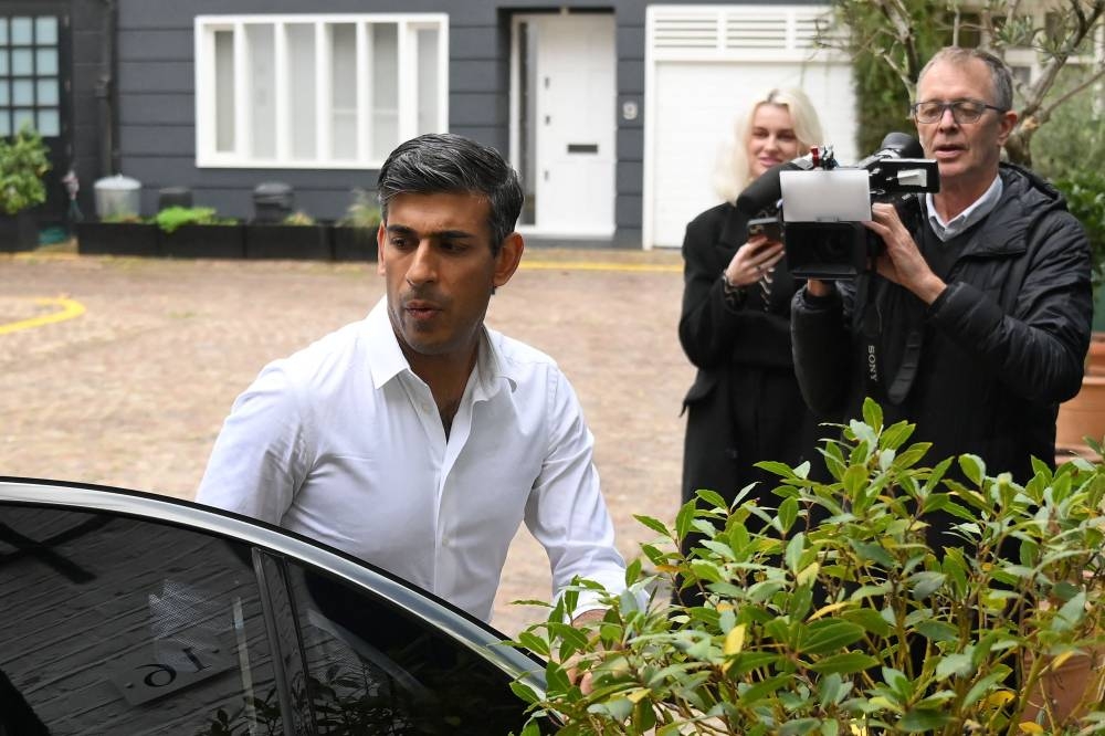 Members of the media film Britain's former Chancellor of the Exchequer, Conservative MP, Rishi Sunak arriving back at his home in London on October 22, 2022. - Former prime minister Boris Johnson on Saturday returned to Britain from a holiday to launch an audacious political comeback, as Conservative leadership rival Rishi Sunak reached the minimum threshold to contest the UK's top job. — AFP pic