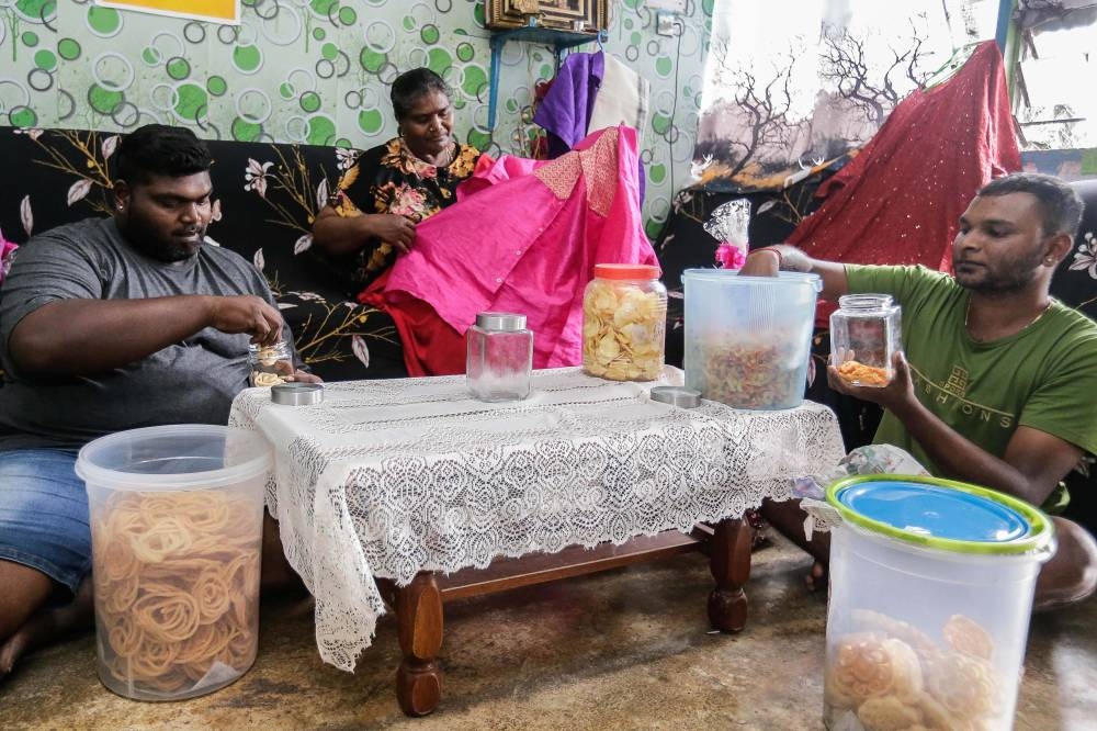 A. Patmavathi (centre), 56, along with her kids P. Jegathis (left), 31, and M. Kubenthiran (right), 22, getting ready as they preparing their home to the up coming Deepavali celebration in Sepang October 23, 2022. — Picture by Sayuti Zainudin