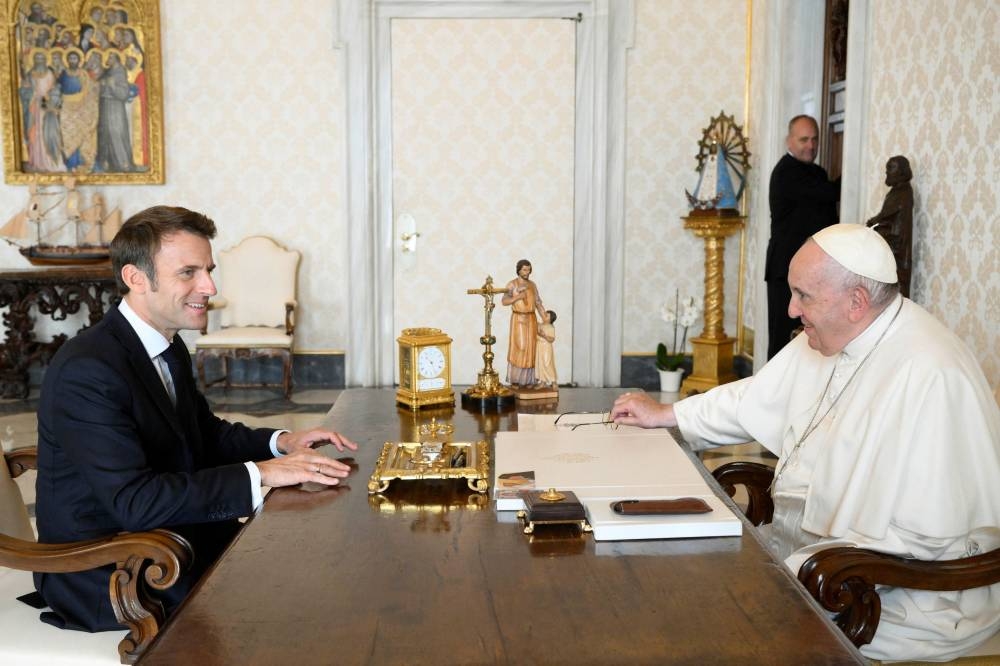 Pope Francis sits with French President Emmanuel Macron for a private audience at the Vatican October 24, 2022. —Vatican Media handout via Reuters