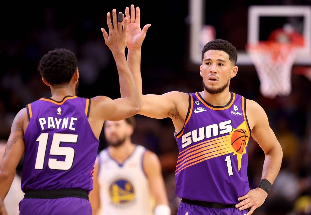 Devin Booker #1 of the Phoenix Sun high fives Cameron Payne #15 after scoring against the Golden State Warriorsduring the first half of the NBA game at Footprint Center on October 25, 2022 in Phoenix, Arizona. — AFP pic