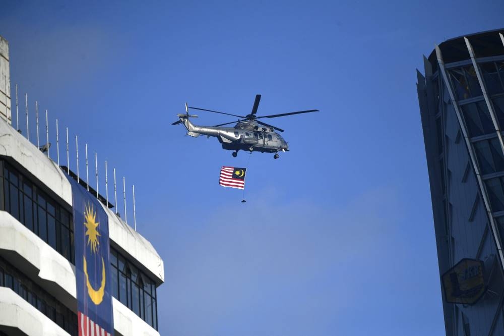 A helicopter bearing the Malaysian flag flies over Dataran Merdeka in Kuala Lumpur August 31, 2022 in this file picture. Perak Fire and Rescue Department director Azmi Osman said there were five passengers, believed to be Health Ministry personnel, and a pilot on board, according to ‘The Star’. — Bernama pic