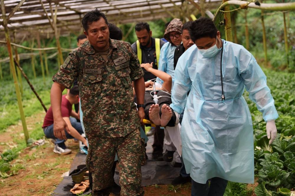 The first victim, a pilot, being brought of the jungle at 5.57pm after being rescued by the Perak Fire and Rescue Department, Cameron Highlands, October 26, 2022. — Bernama pic 
