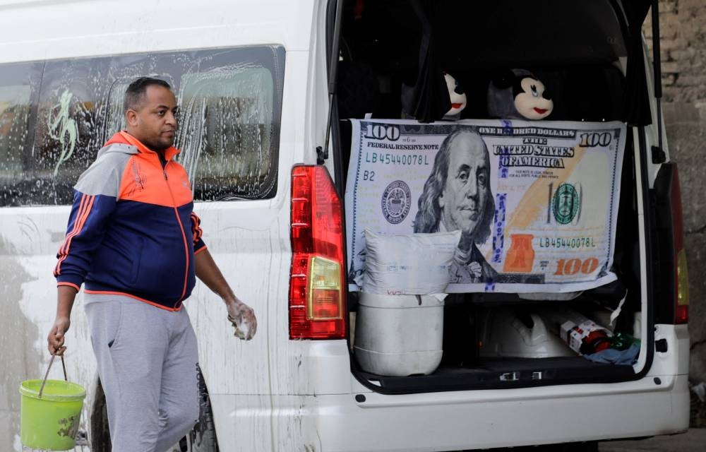 A man washes his car, which has an image of the US dollar displayed, in Cairo, Egypt October 27, 2022. — Reuters pic
