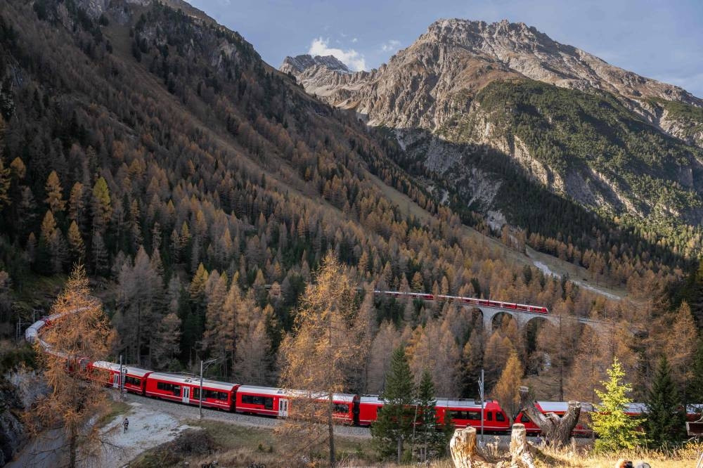 A 1910-metre-long train with 100 cars passes by in Bergun on October 29, 2022, during a record attempt by the Rhaetian Railway (RhB) of the World's longest passenger train, to mark the Swiss railway operator's 175th anniversary. — AFP pic