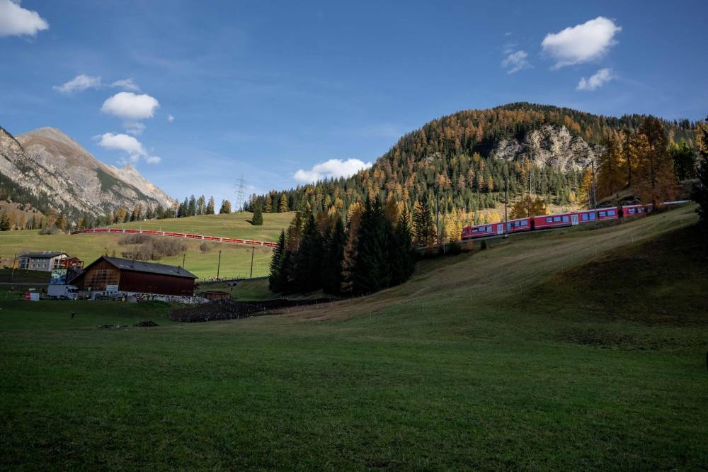 A 1910-metre-long train with 100 cars passes by in Bergun on October 29, 2022, during a record attempt by the Rhaetian Railway (RhB) of the World's longest passenger train, to mark the Swiss railway operator's 175th anniversary. — AFP pic
