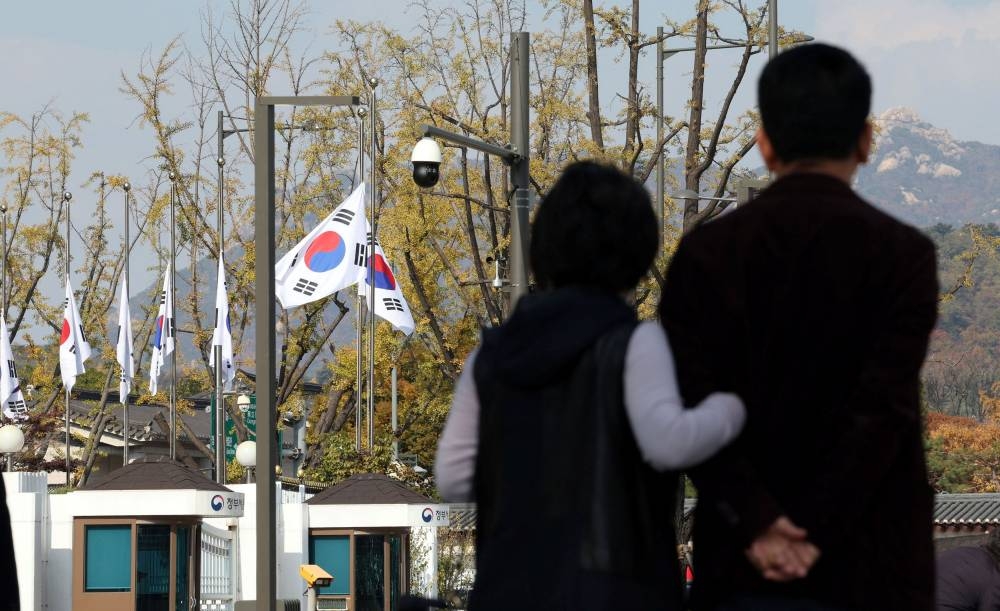 South Korean national flags fly at half-mast at the government complex to mourn the victims of a stampede during Halloween festivities that killed and injured many people at the popular Itaewon district in Seoul, South Korea, in this image released by Yonhap on October 30, 2022. — Yonhap via Reuters pic