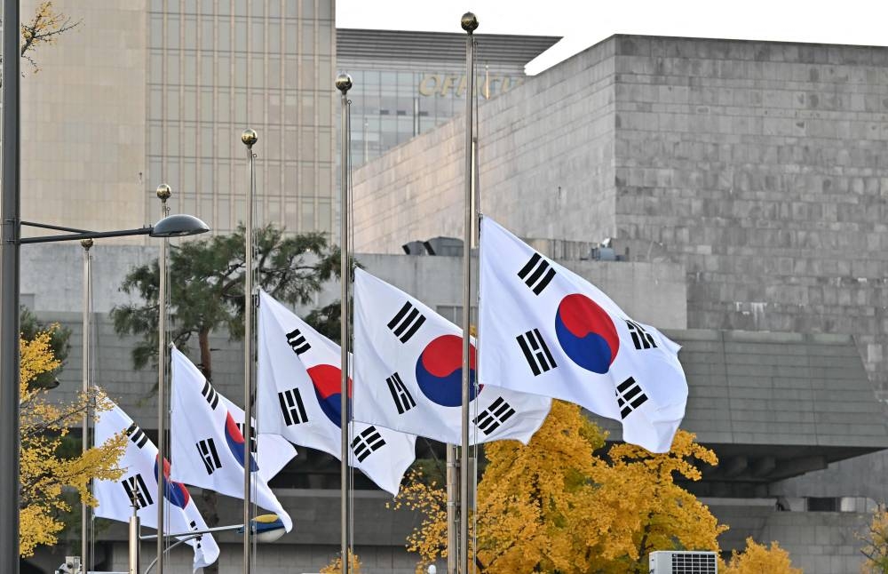South Korean national flags flutter at half-mast at the government complex in Seoul on October 30, 2022, after the deadly Halloween stampede in the capital's popular Itaewon district. — AFP pic