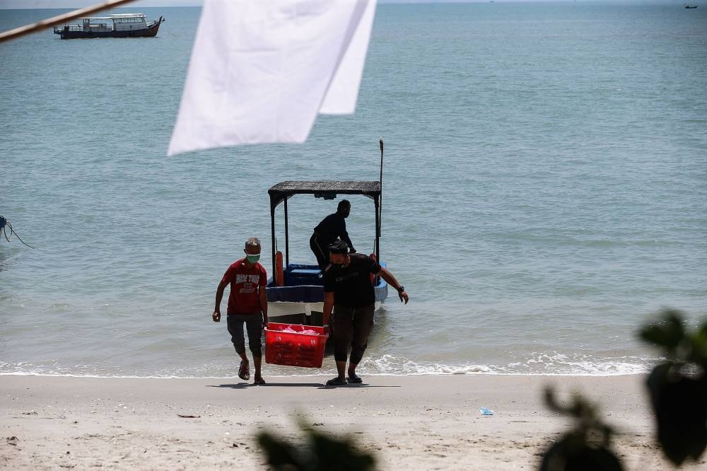 Fishermen return with the day’s catch at the Tanjung Tokong fishing jetty, George Town July 2, 2021. — Picture by Sayuti Zainudin