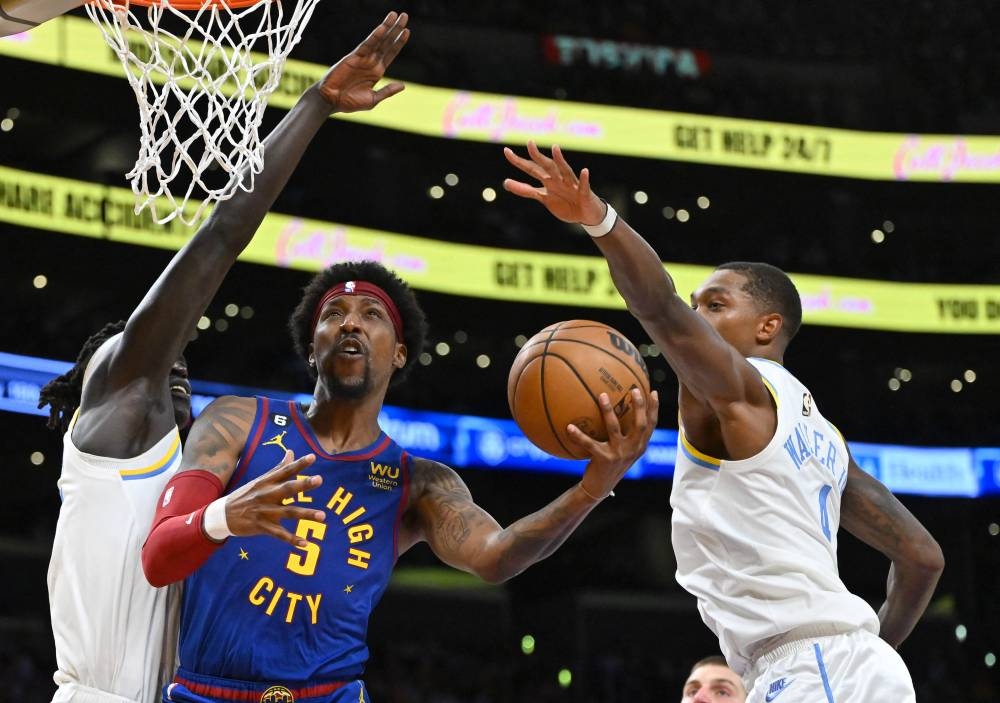 Denver Nuggets guard Kentavious Caldwell-Pope (5) is defended by Los Angeles Lakers forward Wenyen Gabriel (35) and Los Angeles Lakers guard Lonnie Walker IV (4) as he drives to the basket in the first half at Crypto.com Arena October 30, 2022. — Reuters pic