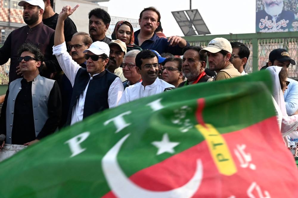 Pakistan's former prime minister Imran Khan (4L) gestures to his supporters during an anti-government march towards Islamabad city, demanding early elections, in Muridke district, about 29 km from Lahore on October 30, 2022. — AFP pic