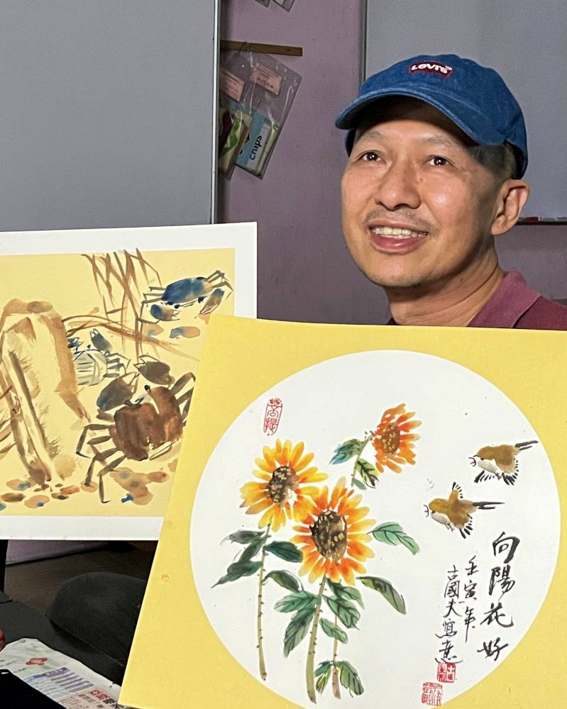 Retired teacher Alfred Koh Keat Fu poses with two of his Chinese ink paintings in Bandar Utama, Gua Musang October 31, 2022. — Bernama pic