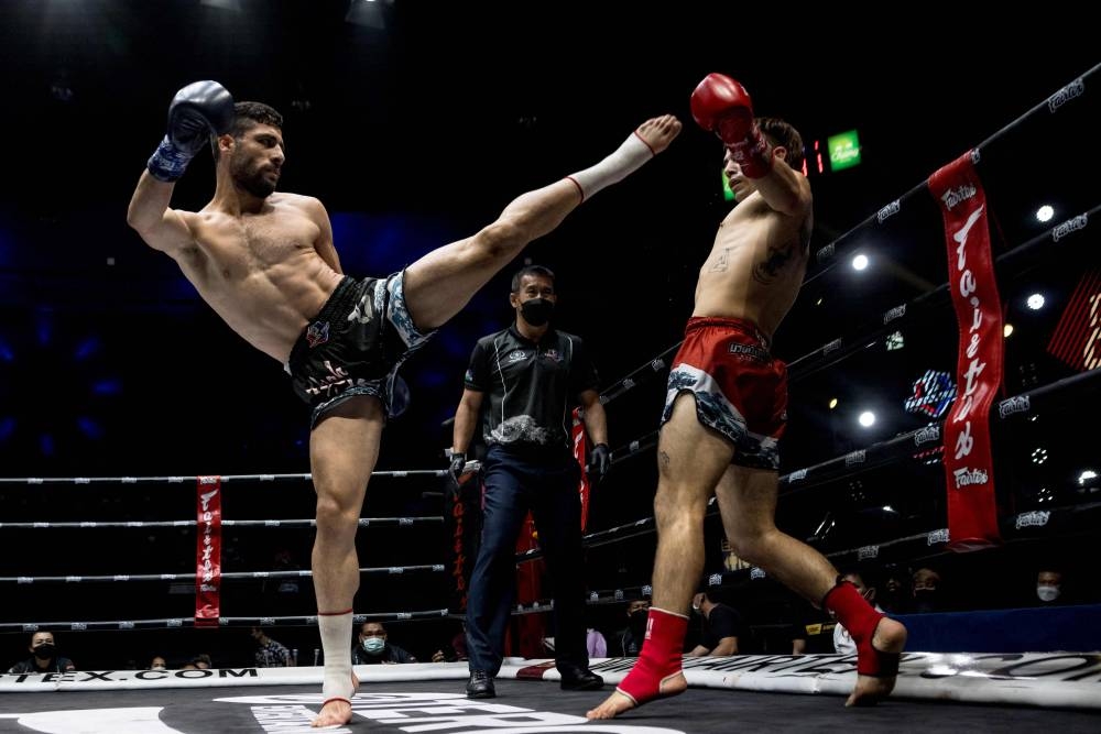 Muay Thai boxers Ali Asghar from Iran and Federico Vernengo (right) from Argentina compete during their fight at Lumpinee Stadium in Bangkok September 24, 2022. — AFP pic