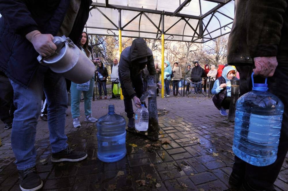 Local residents wait in line to collect water from a public water pump in a park of Kyiv on October 31, 2022. — AFP pic