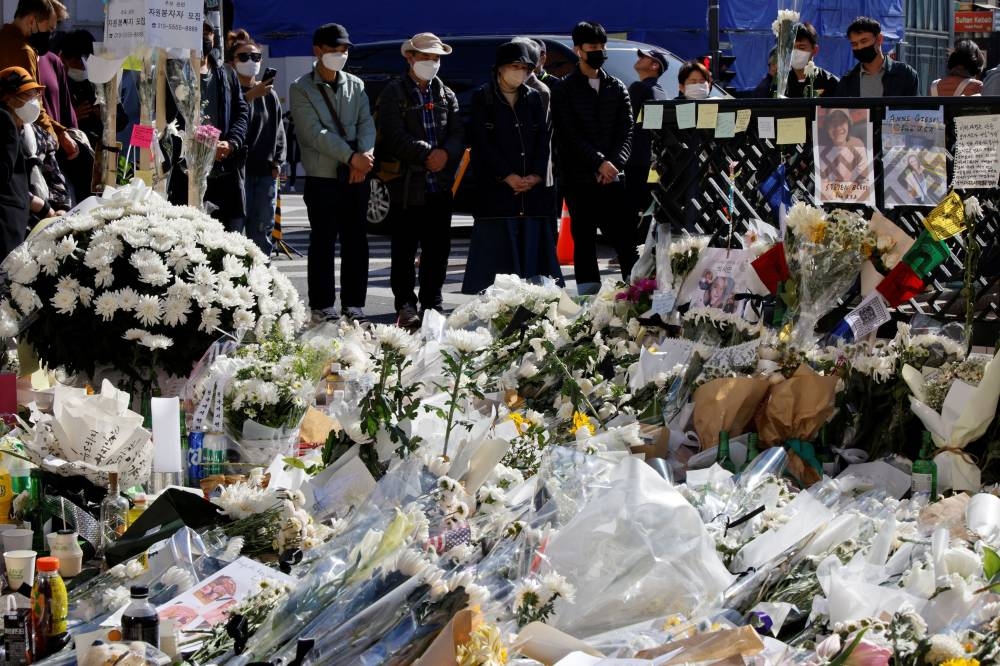 People pay their respects near floral tributes following a crowd crush that happened during Halloween festivities, in Seoul, South Korea, November 2, 2022. — Reuters pic