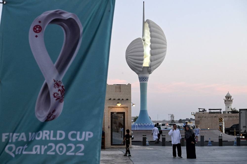 People walk past Fifa World Cup banners in Doha, November 3, 2022, ahead of the Qatar 2022 Fifa World Cup football tournament. — AFP pic 
