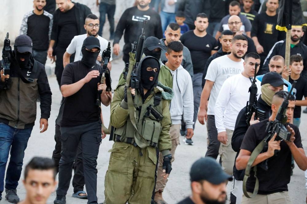People hold guns as Palestinians react after Israeli forces killed Islamic Jihad militant Farouq Salama, 28, during a raid in Jenin, in the Israeli-occupied West Bank November 3, 2022. — Reuters pic