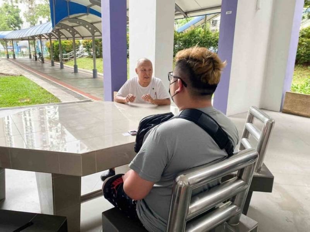 The victim’s nephew (back facing), who wanted to be known only as Lee, and Ng Swee Meng, brother-in-law of the deceased. — TODAY pic