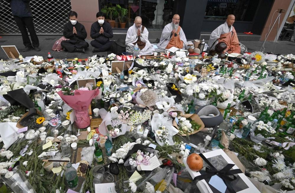 South Korean Buddhist monks pray at a makeshift memorial for the victims of the deadly Halloween crowd surge, outside a subway station in the district of Itaewon in Seoul November 3, 2022. — AFP pic