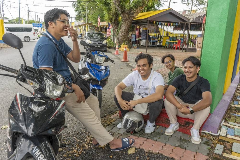Deen (seated right), and his friends Adam (seated left), Haziq (seated in the background) and Muhsin (standing) in Arau, Perlis November 5, 2022. — Picture by Shafwan Zaidon